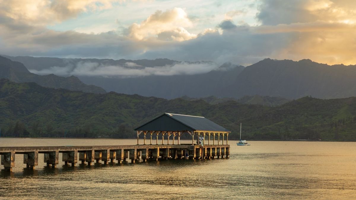Hanalei Pier on Kauai with mountains behind it at sunset, near Black Pot Beach Park parking