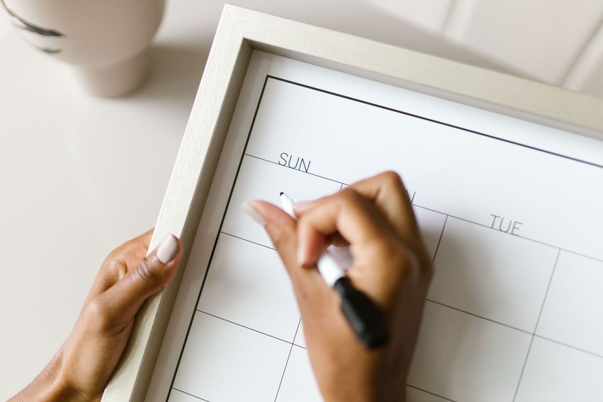 Hawaii reservations calendar: a hand writing dates on a wall calendar