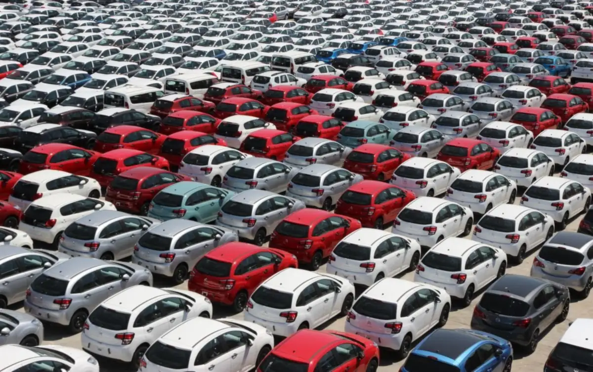 Overhead view of rental cars parked in neat rows in a large outdoor lot