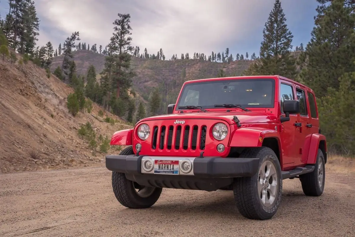 Lanai car rental guide: a red Jeep parked on a dirt road (stock photo)
